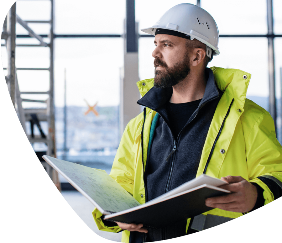 man on site with blueprints in high vis and hard hat