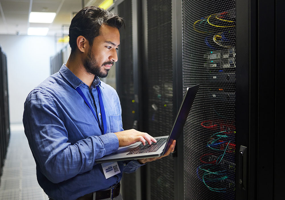 man by server with laptop