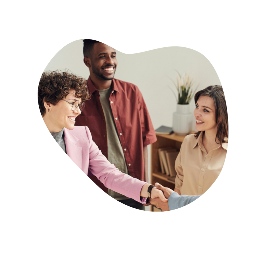 three people smiling and shaking hands